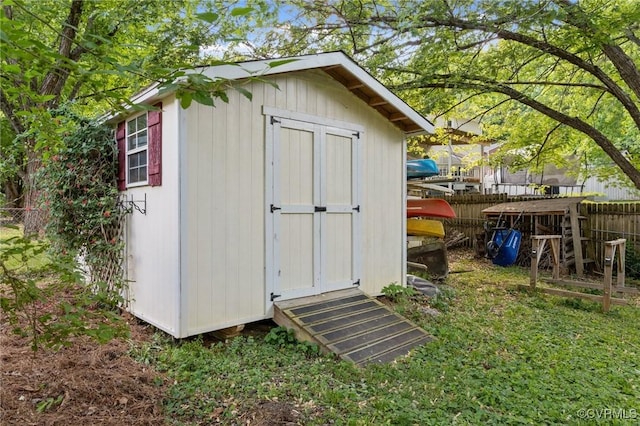 view of shed featuring fence