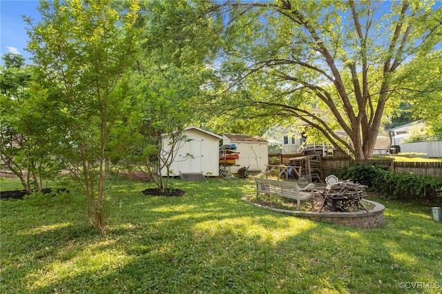 view of yard with fence, an outdoor structure, and a shed