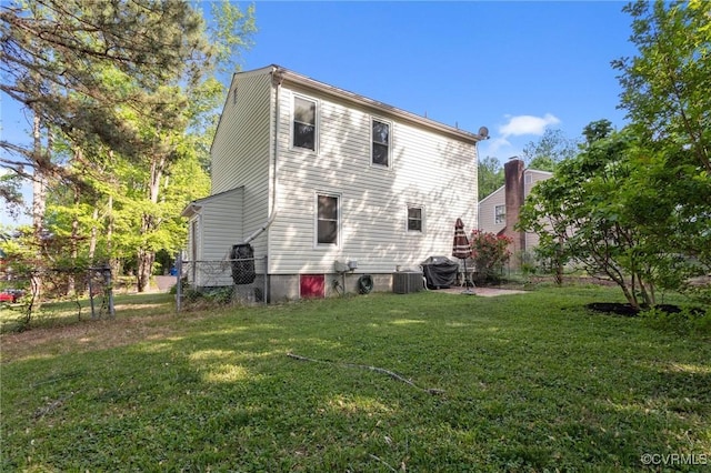 back of property featuring a lawn, fence, and cooling unit