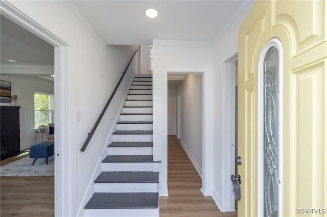 stairway featuring crown molding, baseboards, recessed lighting, and wood finished floors