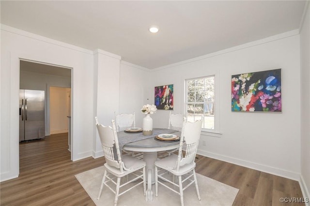 dining area with baseboards and wood finished floors