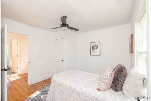 bedroom with a ceiling fan, visible vents, light wood-type flooring, baseboards, and a closet