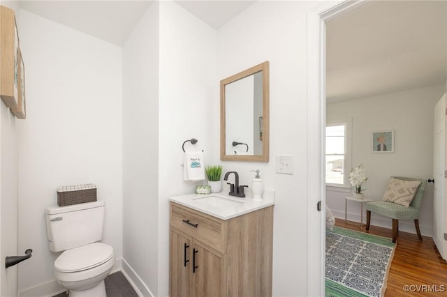 bathroom featuring vanity, baseboards, toilet, and wood finished floors