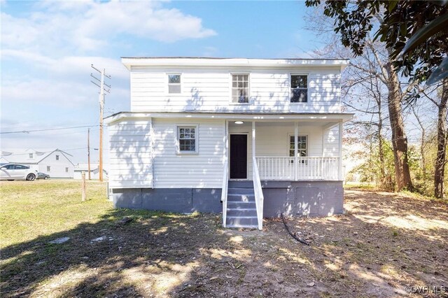 view of front facade featuring covered porch and a front lawn