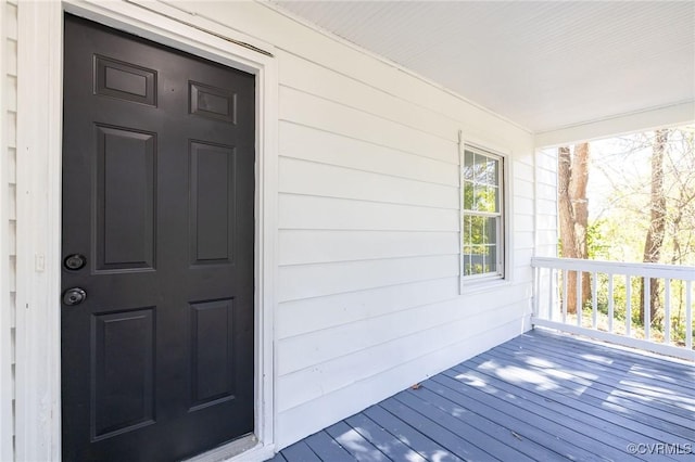 view of exterior entry featuring covered porch