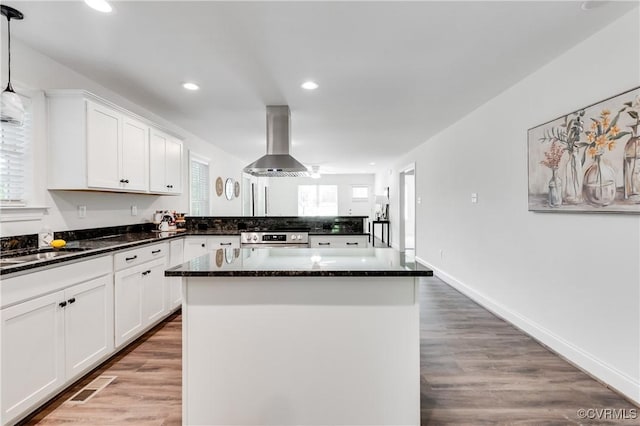 1217 Darbytown Rd, Richmond, VA 23231 - kitchen with stainless steel range with electric stovetop, extractor fan, a center island, white cabinetry, and visible vents