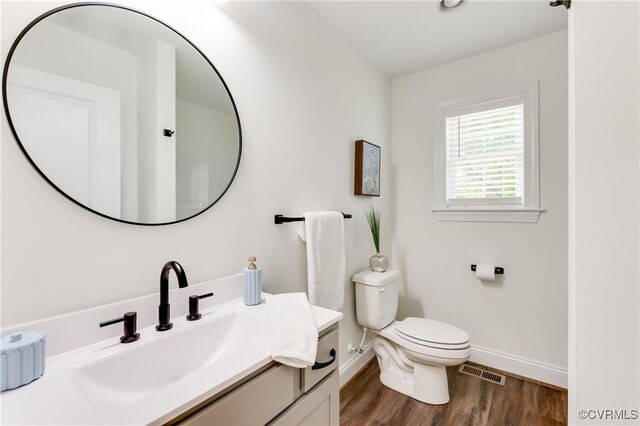 1217 Darbytown Rd, Richmond, VA 23231 - bathroom with vanity, toilet, baseboards, wood finished floors, and visible vents