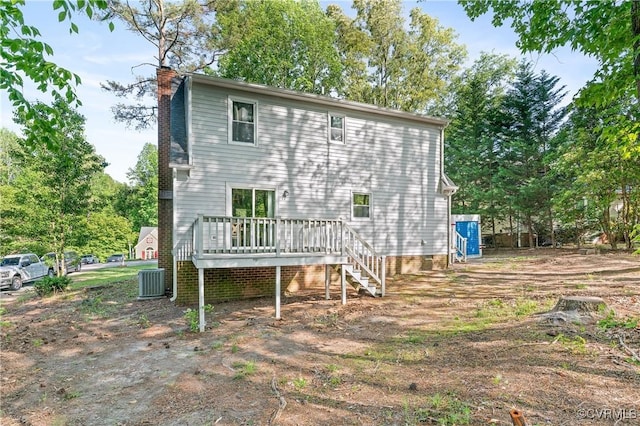 rear view of house featuring a wooden deck, stairs, and a chimney