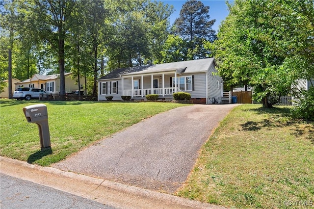 view of front of property with covered porch, crawl space, a front yard, fence, and aphalt driveway
