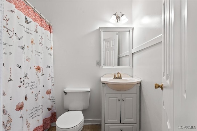 bathroom with vanity, baseboards, a shower with shower curtain, and toilet