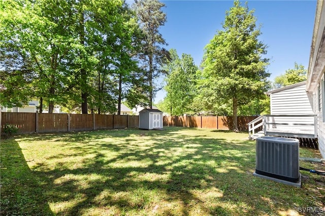 view of yard featuring a storage shed, an outdoor structure, cooling unit, and a fenced backyard