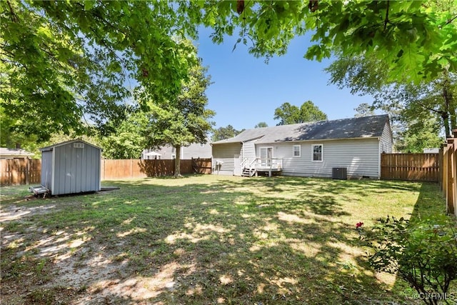view of yard with central air condition unit, a fenced backyard, and a shed