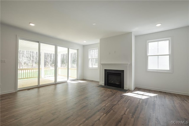 6081 Brickshire Dr, Providence Forge, VA 23140 - unfurnished living room featuring baseboards, dark wood finished floors, a fireplace with flush hearth, and a healthy amount of sunlight