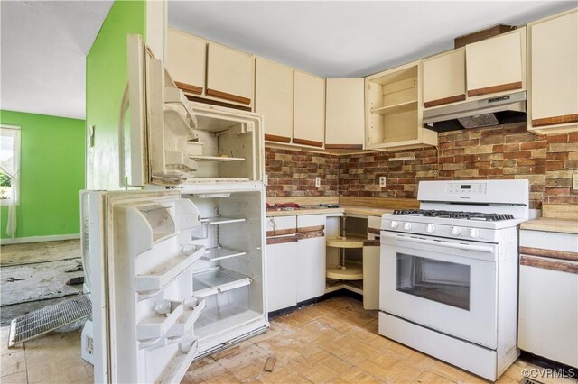 kitchen featuring open shelves, under cabinet range hood, white appliances, and cream cabinetry