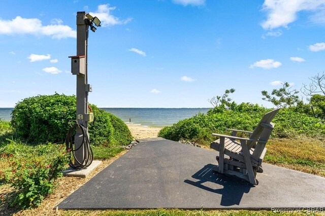 view of community with a beach view and a water view