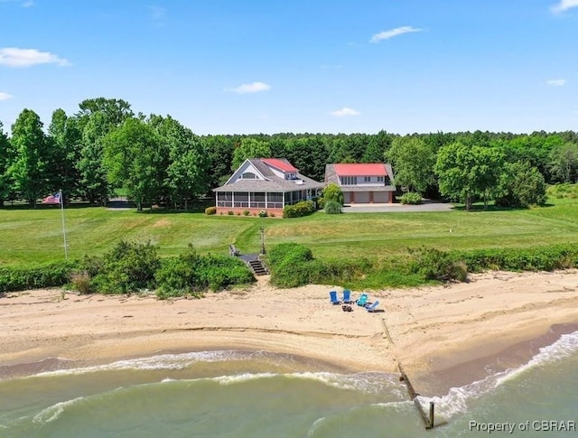 birds eye view of property with a water view, a view of the beach, and a wooded view