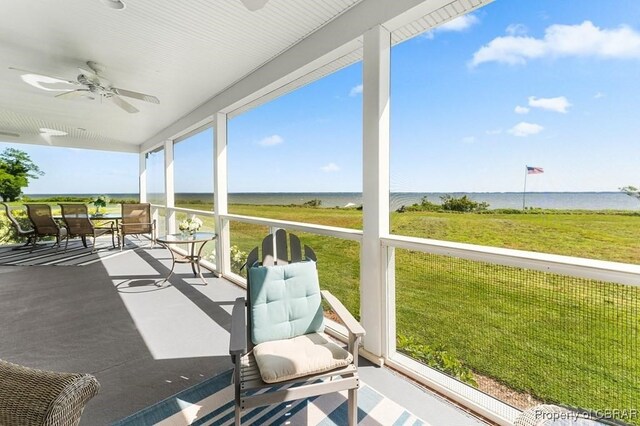 sunroom featuring a water view and ceiling fan