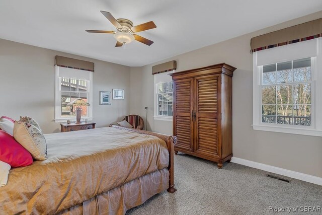 carpeted bedroom with visible vents, a ceiling fan, and baseboards