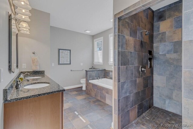 bathroom with double vanity, a garden tub, a sink, toilet, and tiled shower