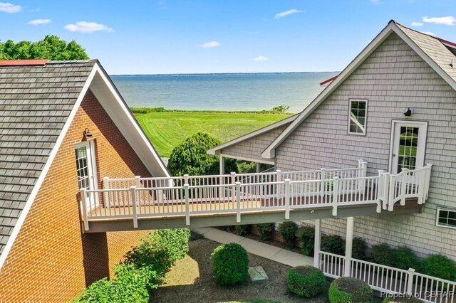 rear view of house with a deck with water view