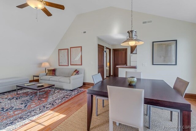 dining room with visible vents, a ceiling fan, lofted ceiling, and wood finished floors