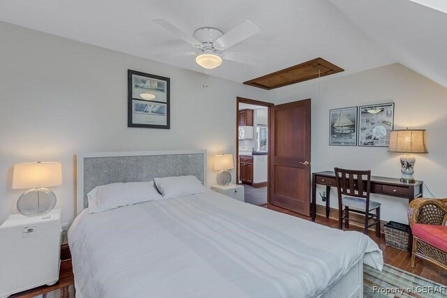 bedroom featuring a ceiling fan, attic access, wood finished floors, and lofted ceiling