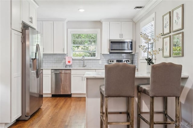 kitchen featuring light countertops, stainless steel appliances, visible vents, and a sink