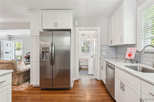 kitchen featuring a sink, stainless steel appliances, white cabinetry, light countertops, and dark wood-style floors