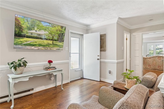 interior space featuring baseboards, baseboard heating, crown molding, and wood finished floors