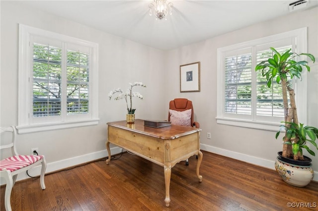 office space with baseboards, visible vents, and wood finished floors
