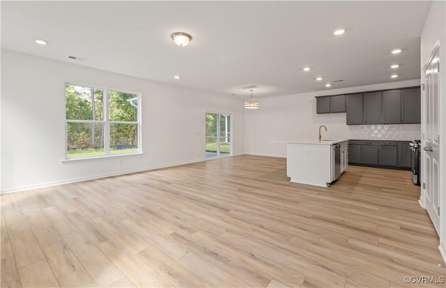 kitchen featuring a sink, appliances with stainless steel finishes, recessed lighting, and open floor plan