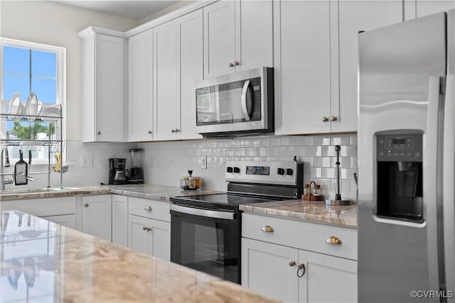 925 Scott Commons Ln, Henrico, VA 23227 - kitchen featuring backsplash, appliances with stainless steel finishes, light stone countertops, a sink, and white cabinets