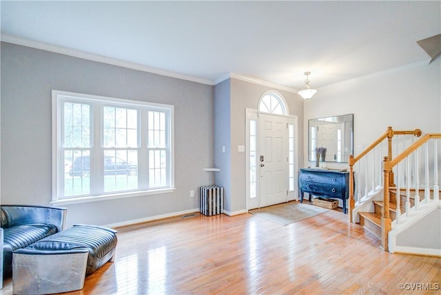 entrance foyer with wood finished floors, crown molding, stairs, radiator, and baseboards