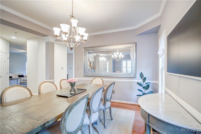 dining area featuring a chandelier, wood finished floors, and ornamental molding
