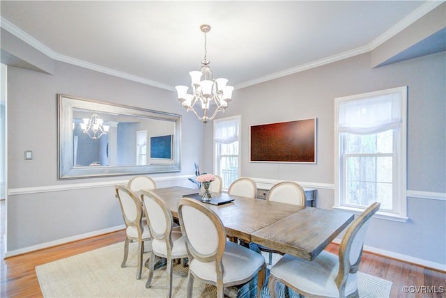 dining room with a chandelier, wood finished floors, crown molding, and baseboards