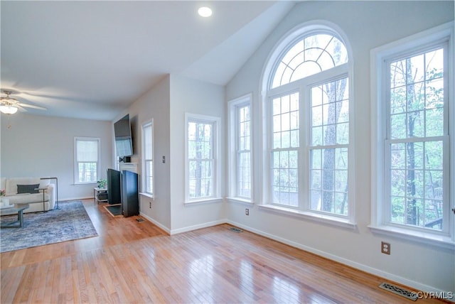 foyer entrance with wood finished floors, baseboards, ceiling fan, and lofted ceiling