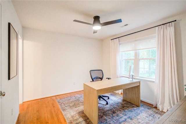 office space featuring light wood-type flooring, ceiling fan, and baseboards