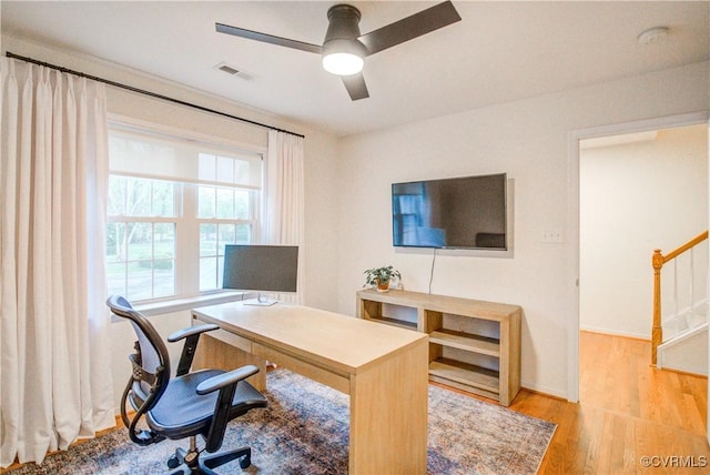 office space featuring wood finished floors, a ceiling fan, and baseboards