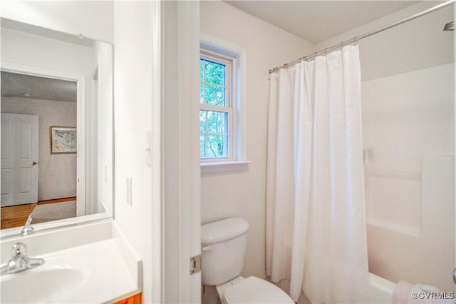 bathroom featuring toilet, vanity, and shower / tub combo