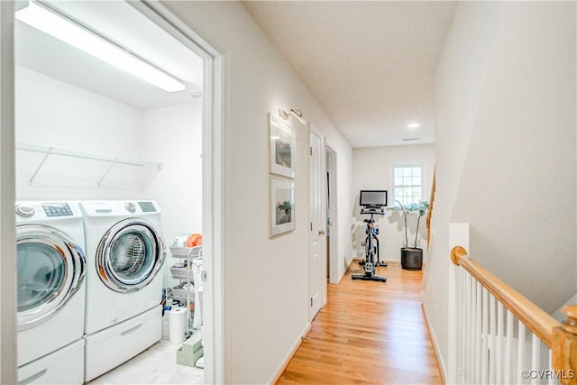 clothes washing area with separate washer and dryer, light wood-style flooring, baseboards, and recessed lighting