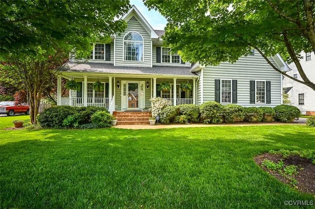 view of front of property featuring roof with shingles, covered porch, and a front yard