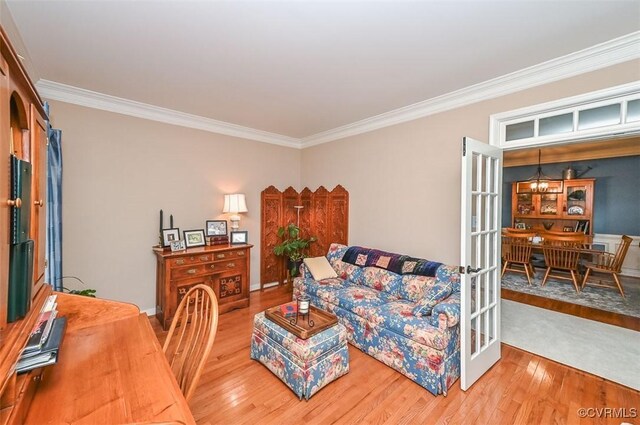living room with ornamental molding and wood finished floors
