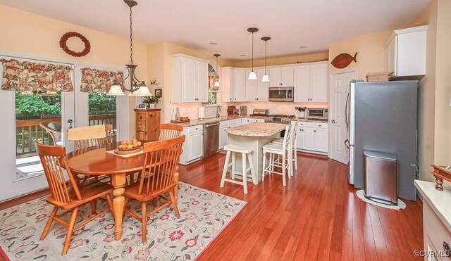 dining space with wood finished floors and a toaster