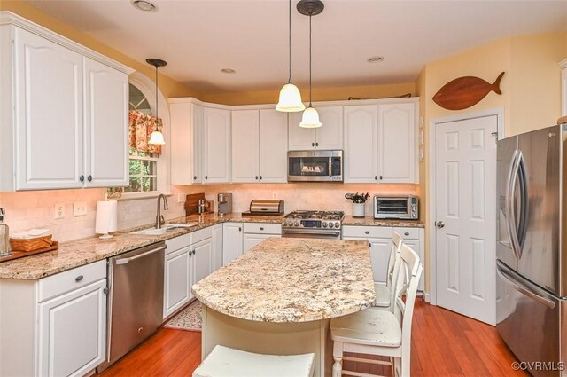 kitchen with a sink, white cabinets, stainless steel appliances, and a toaster