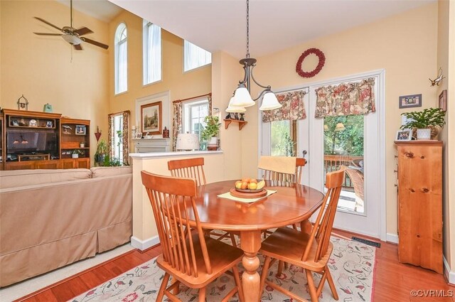 dining space featuring baseboards, ceiling fan, visible vents, and wood finished floors