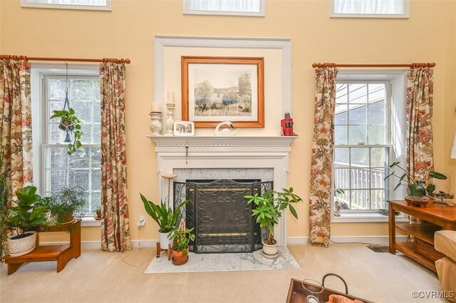 living area featuring carpet, baseboards, and a fireplace