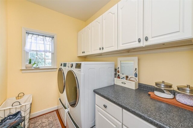 laundry room with baseboards, cabinet space, and washing machine and clothes dryer