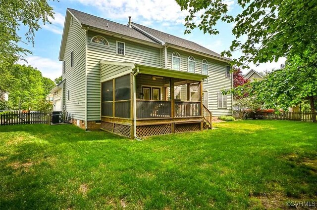 back of house with a yard, a deck, a fenced backyard, and a sunroom