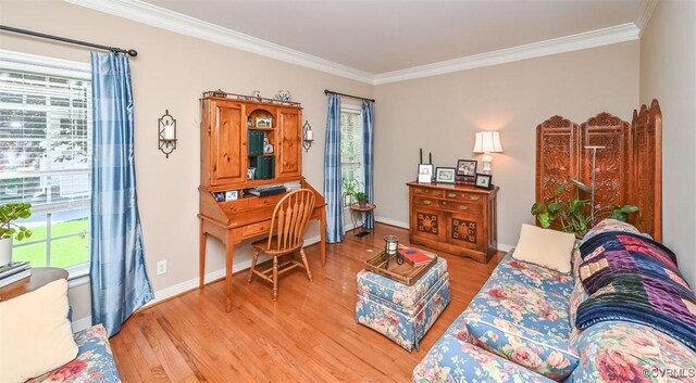 living area featuring plenty of natural light, light wood-style flooring, and crown molding