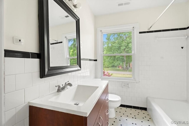 full bathroom featuring visible vents, tile walls, vanity, tile patterned floors, and toilet